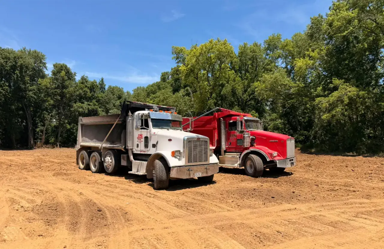 Two J1S dump trucks parked side by side