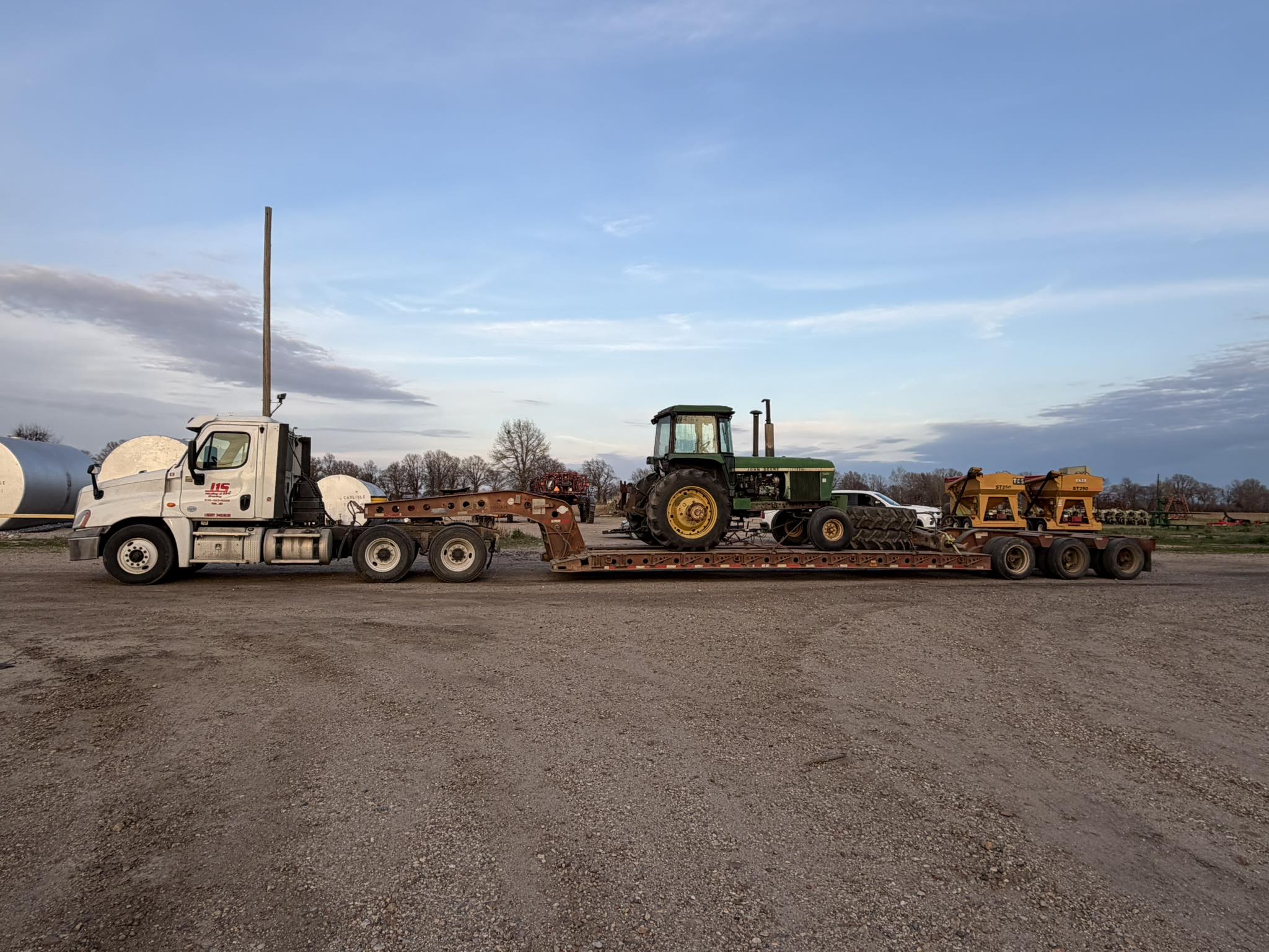 A J1S semi hauling a tractor and equipment on a lowboy trailer